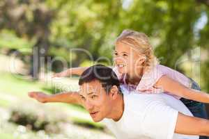 Little girl playing with her father in the park