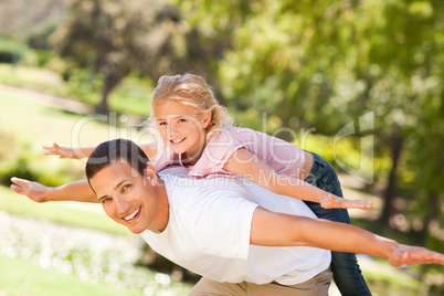 Little girl playing with her father in the park