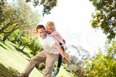 Little girl playing with her father in the park