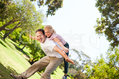 Little girl playing with her father in the park