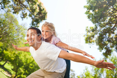 Father playing with his daughter in the park