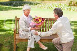 Senior man offering flowers to his wife