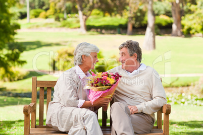 Senior man offering flowers to his wife