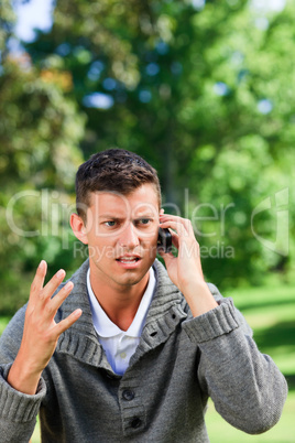 Young man phoning on the bench