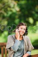 Beautiful woman phoning on the bench