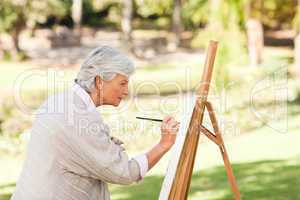 Mature woman painting in the park