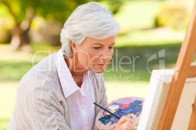 Mature woman painting in the park