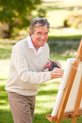 Elderly man painting in the park