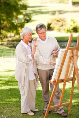 Retired couple painting in the park