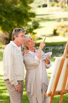 Senior couple painting in the park