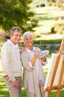 Senior couple painting in the park