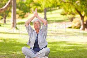 Senior woman practicing yoga in the park