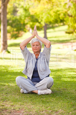 Senior woman practicing yoga in the park