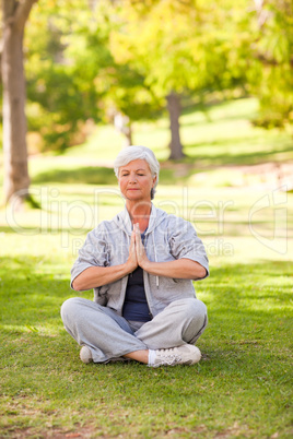 Senior woman practicing yoga in the park