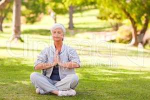 Senior woman practicing yoga in the park