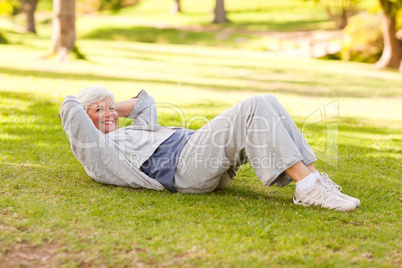 Retired woman doing her stretches in the park