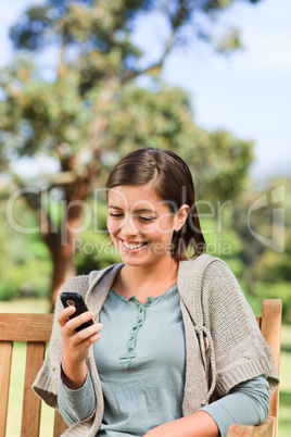 Young woman phoning on the bench