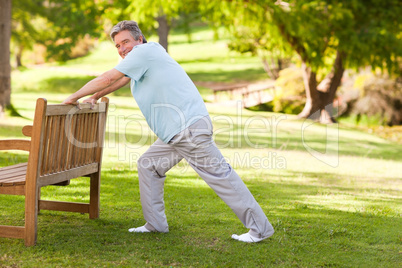 Retired man doing his stretches in the park