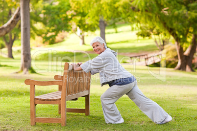 Senior woman doing her stretches in the park