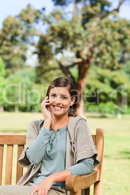 Young woman phoning on the bench