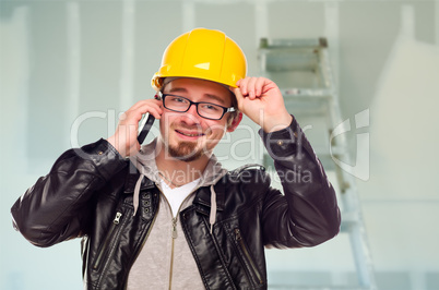 Contractor in Hard Hat on Cell Phone In Unfinished House