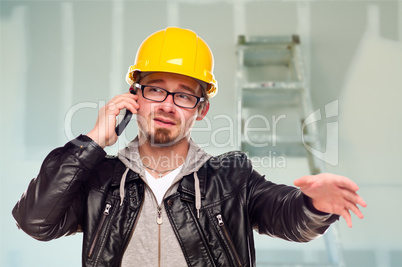 Contractor in Hard Hat on Cell Phone In Unfinished House