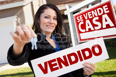Hispanic Woman Holding Vendido Sign in Front of Se Vende Casa Si
