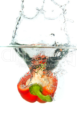 Red paprika in water splash isolated on white