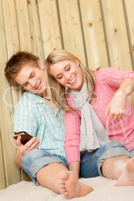 Couple in love - summer fun on beach with music