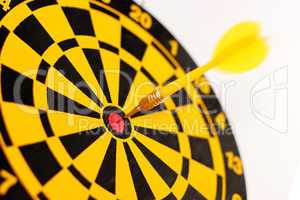 A yellow dart on a bull's-eye