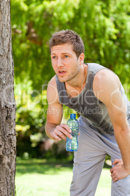 Sporty man drinking water in the park