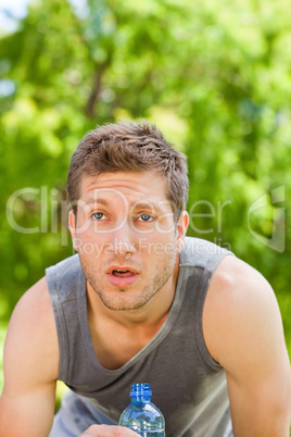 Sporty man drinking water in the park