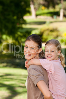 Beautiful mother giving daughter a piggyback