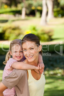 Beautiful mother giving daughter a piggyback