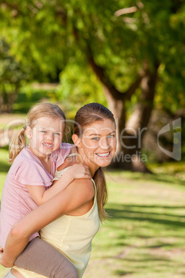 Beautiful mother giving daughter a piggyback