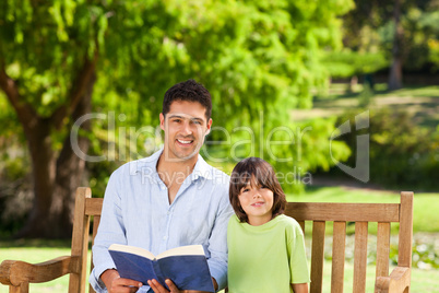 Son with his father reading a book