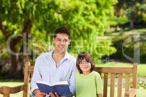 Son with his father reading a book