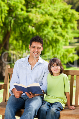 Son with his father reading a book