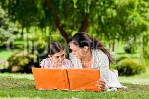 Mother and her daughter looking at their album photo