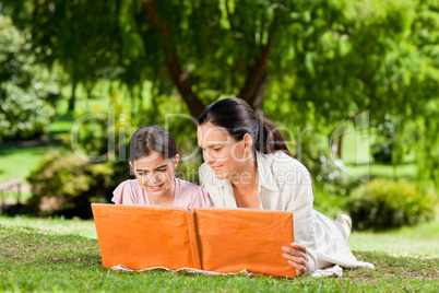 Mother and her daughter looking at their album photo