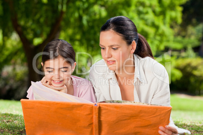Mother and her daughter looking at their album photo