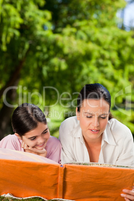 Mother and her daughter looking at their album photo