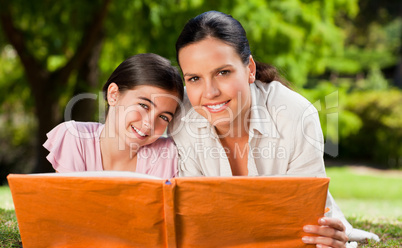 Mother and her daughter looking at their album photo