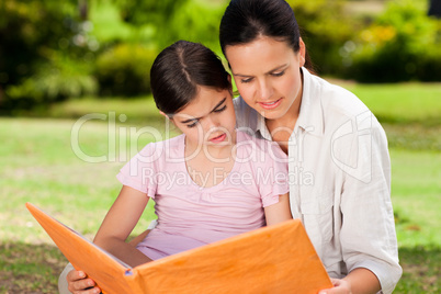 Daughter and her mother looking at their album photo