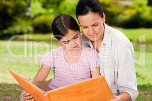 Daughter and her mother looking at their album photo