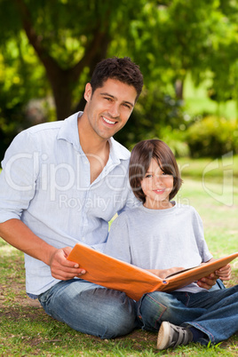 Son with his father looking at their album photo