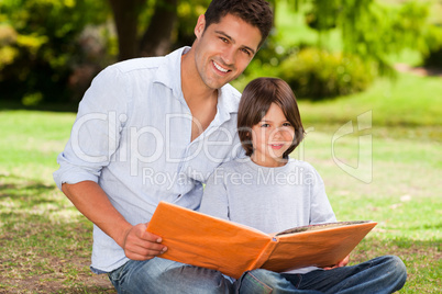 Son with his father looking at their album photo