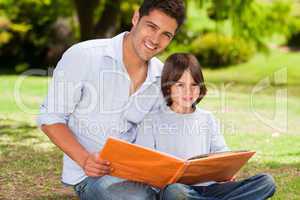 Son with his father looking at their album photo