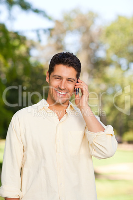 Handsome man phoning in the park