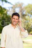 Handsome man phoning in the park